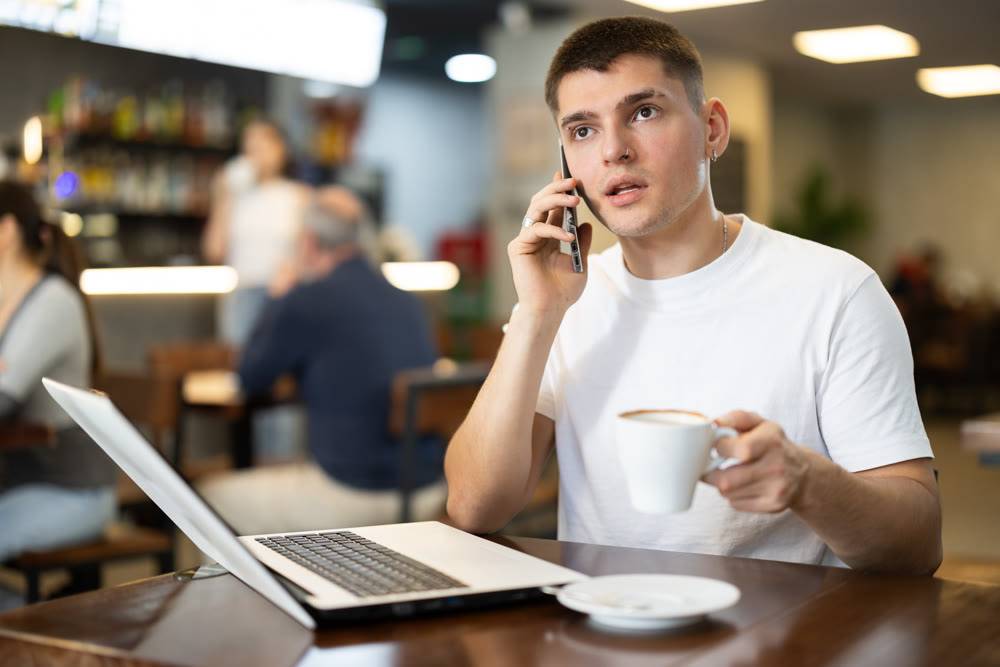 Guy working on laptop and answering call