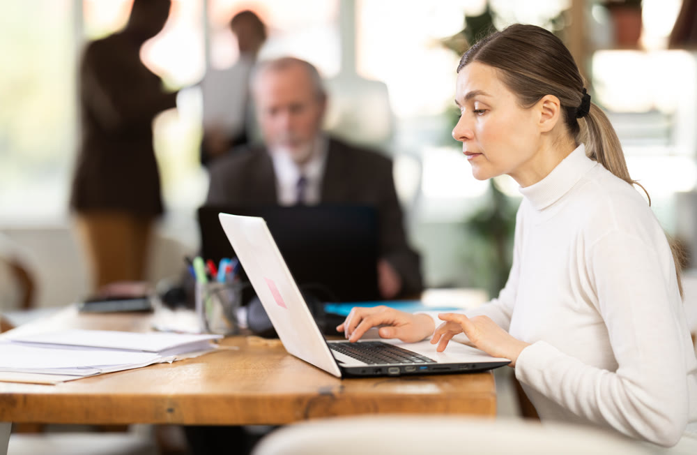 Businesswoman works in company office along with other office workers