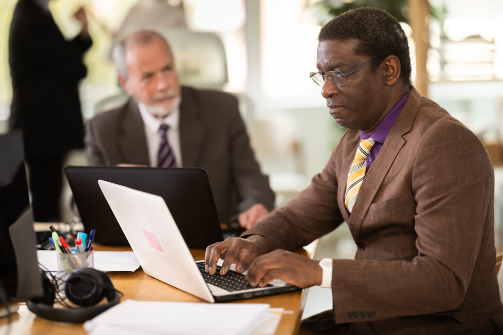 African man working in office with team