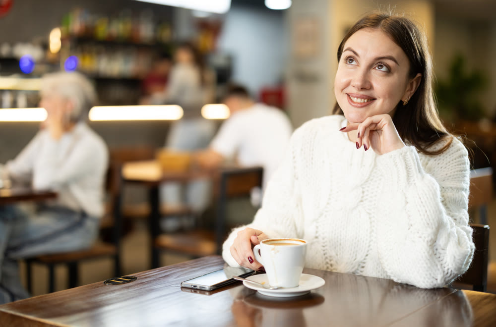 Young woman drinks cup of coffee