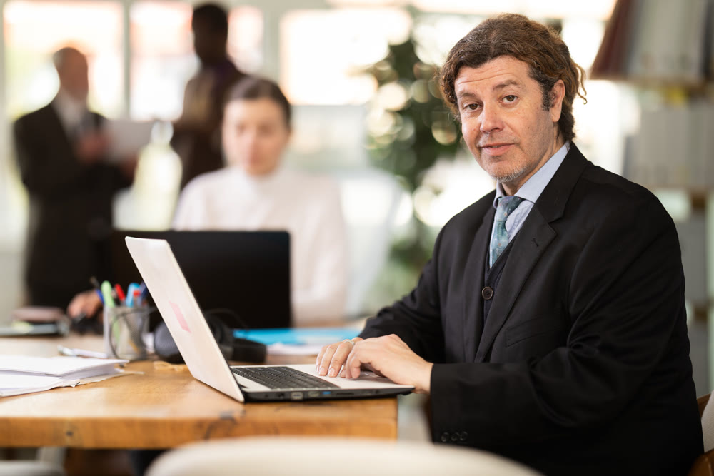 Businessman works in company office along with other office workers