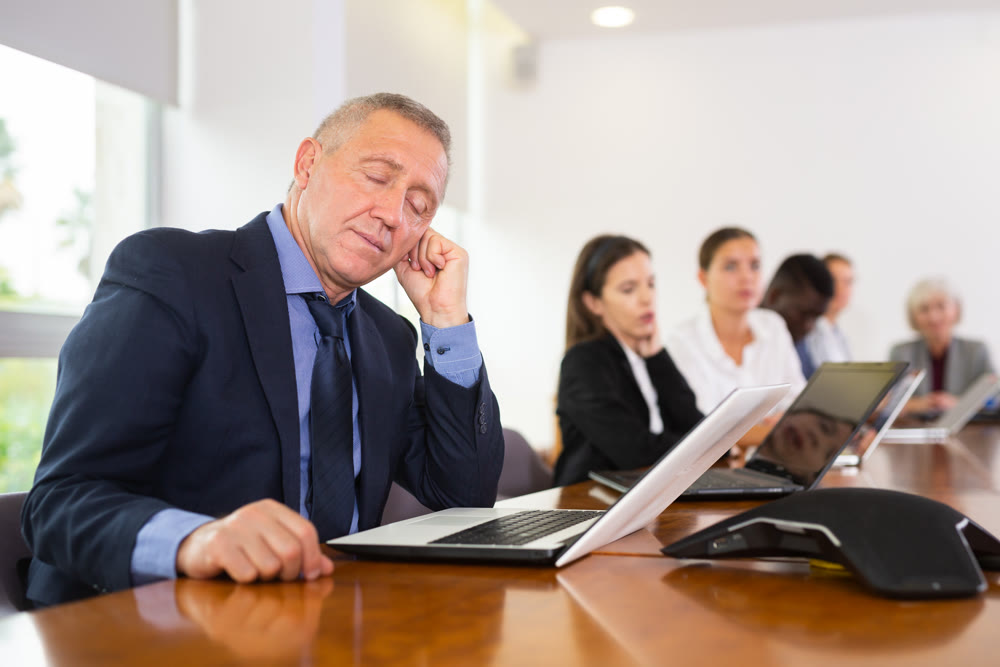 Man in suit sleeping during conference