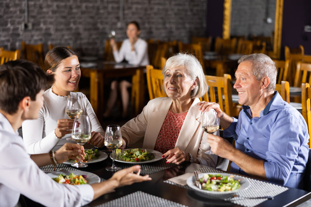 Happy senior couple meeting with adult children in restaurant