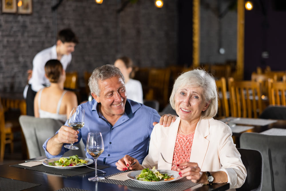 Happy senior couple having dinner together in restaurant