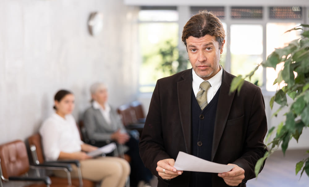 Adult man posing with documents in office