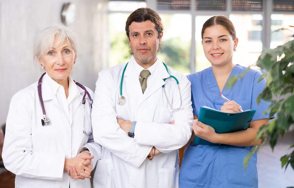 Portrait of two doctors and female nurse at office of medical clinic