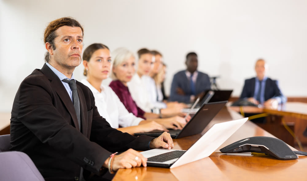 Focused man listening to lecture at conference in meeting room