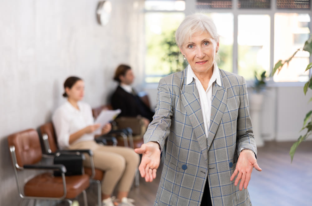 Seniore positive woman extending her hand for handshake in office