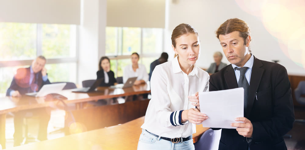 Senior manager checking documents from female manager in a meeting room