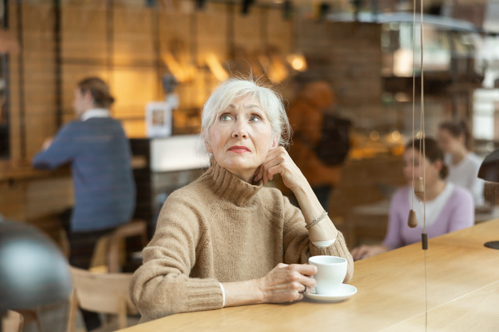 Calm mature woman enjoying peace and quiet alone in cozy cafe