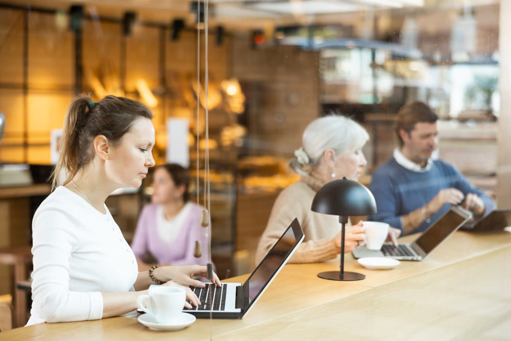 Woman spending time in cozy coffeehouse with laptop and coffee