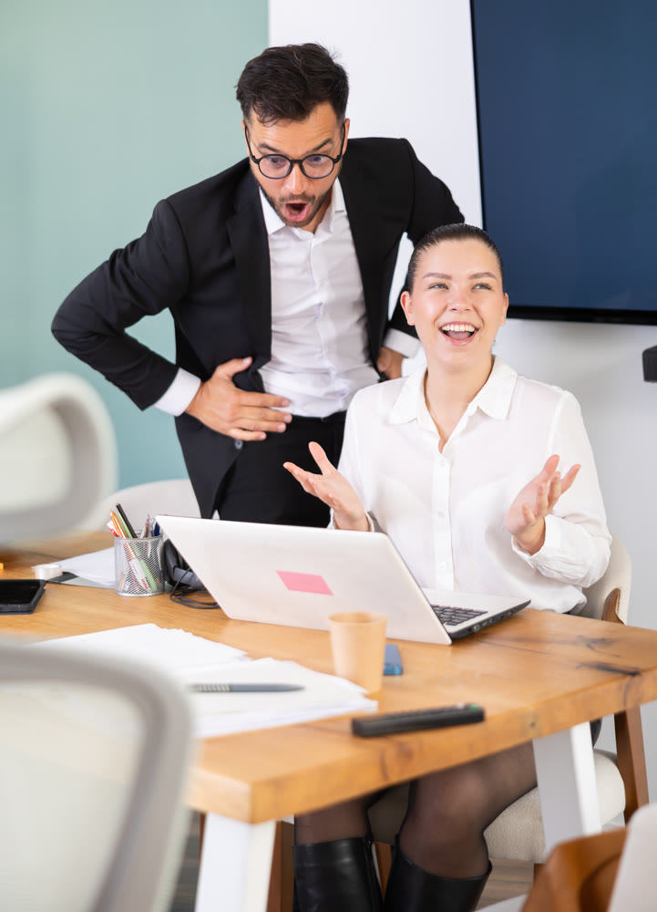 Man and a woman work in an office and are emotionally joy about the success in a new project