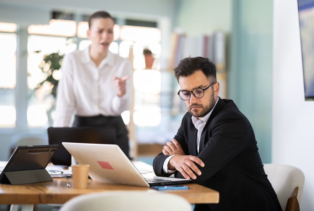 female boss stands in the office and scolds on a male IT department employee