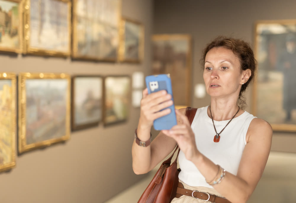 Adult woman taking photo of art gallery