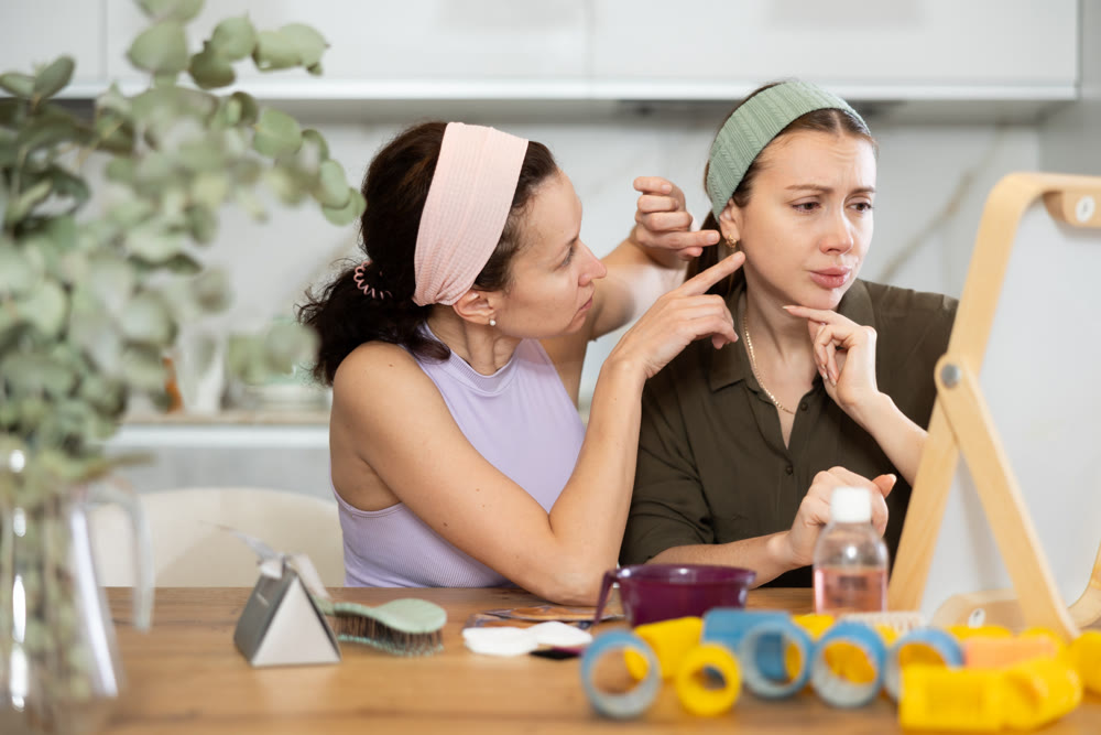 Two women looking at themselves in mirror