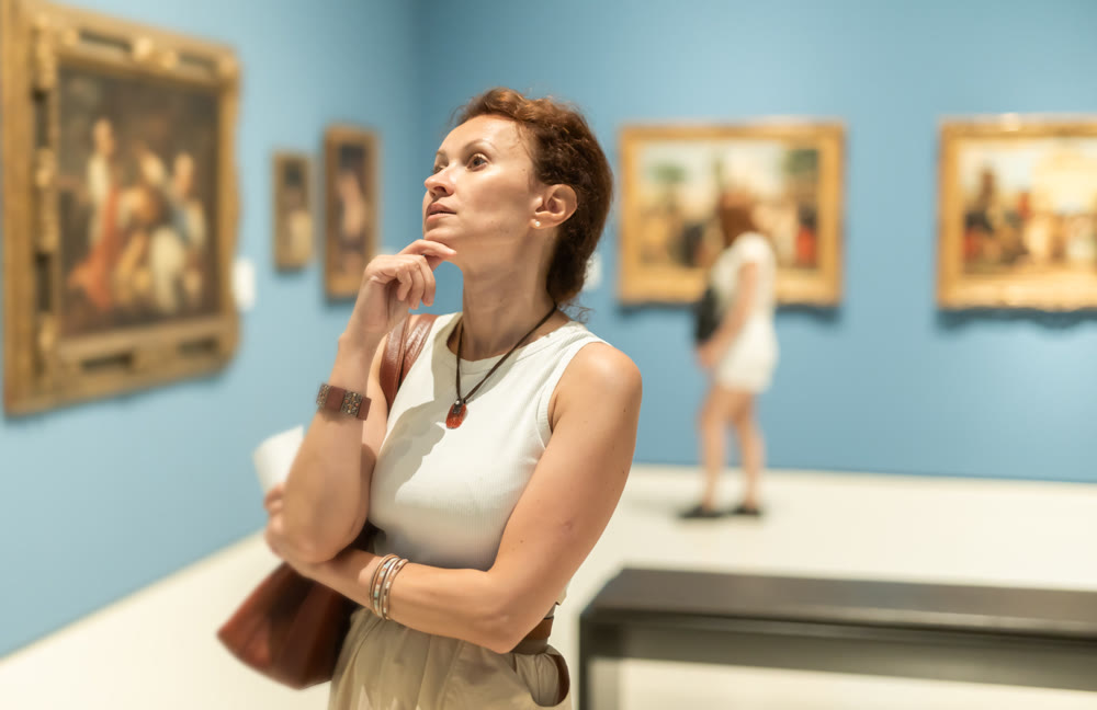 Woman viewing art gallery with brochure