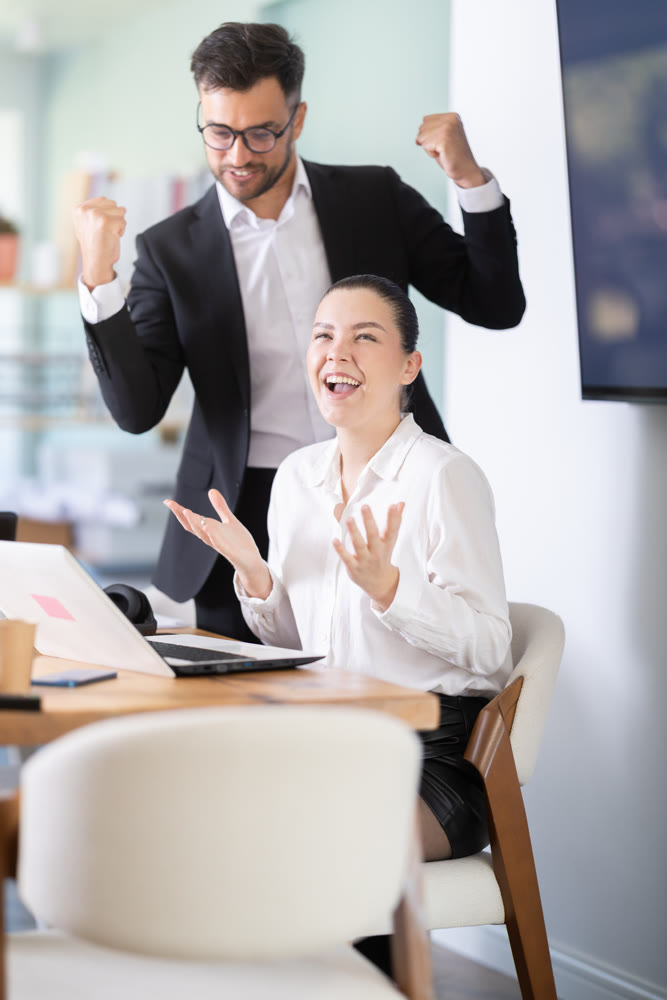 Man and a woman work in an office and are emotionally joy about the success in a new project