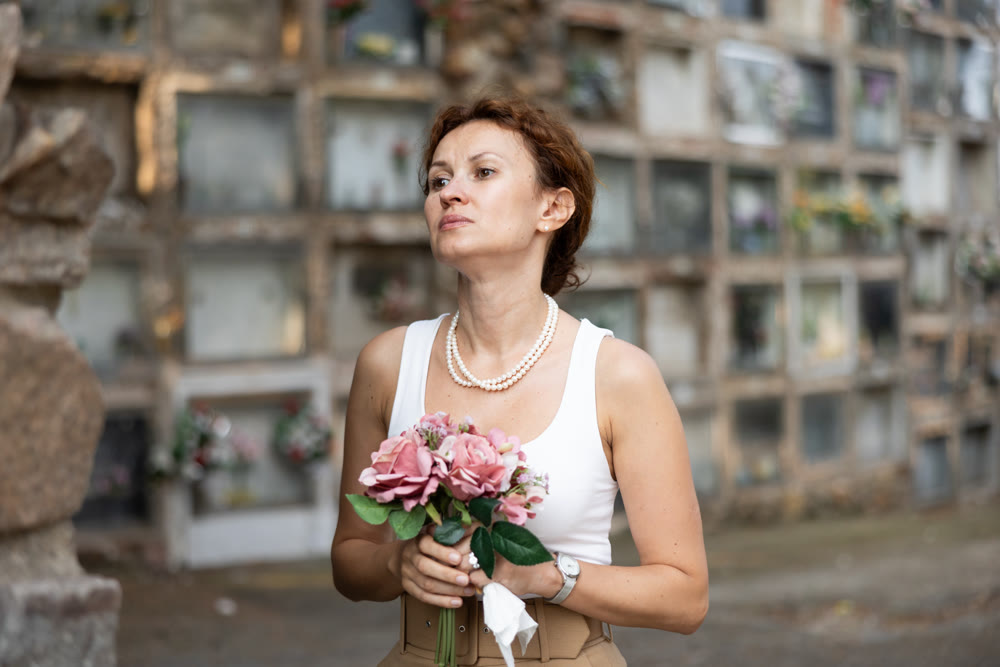 Upset woman remembers deceased relative at cemetery