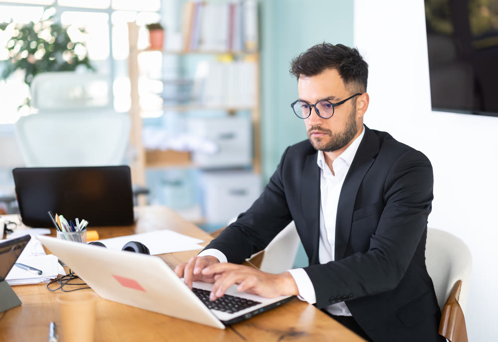 Man working in office, manager using laptop in work