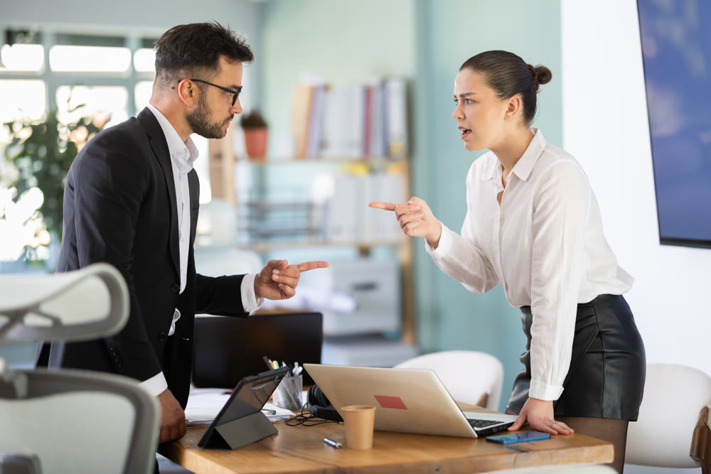 Man and girl colleagues are arguing excitedly in office