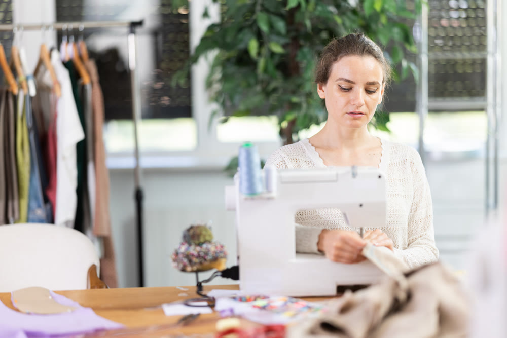 Woman tailor at work in cloth design shop