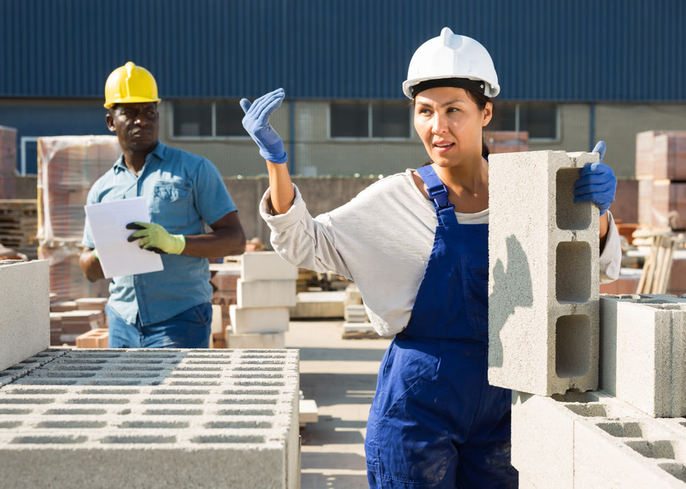 Man and woman working in outdoor construction material storage