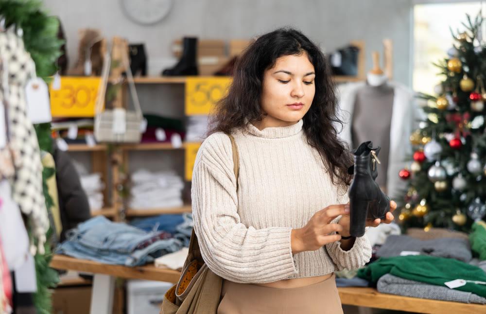 Latina chooses heeled boots on the background of a Christmas tree
