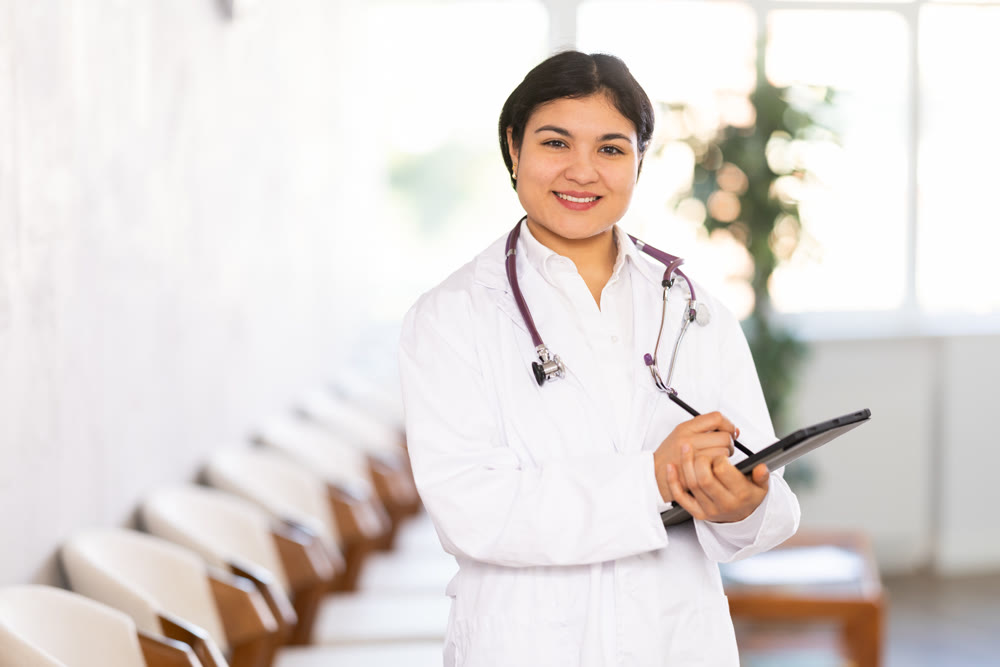 Portrait of friendly female medical receptionist with tablet