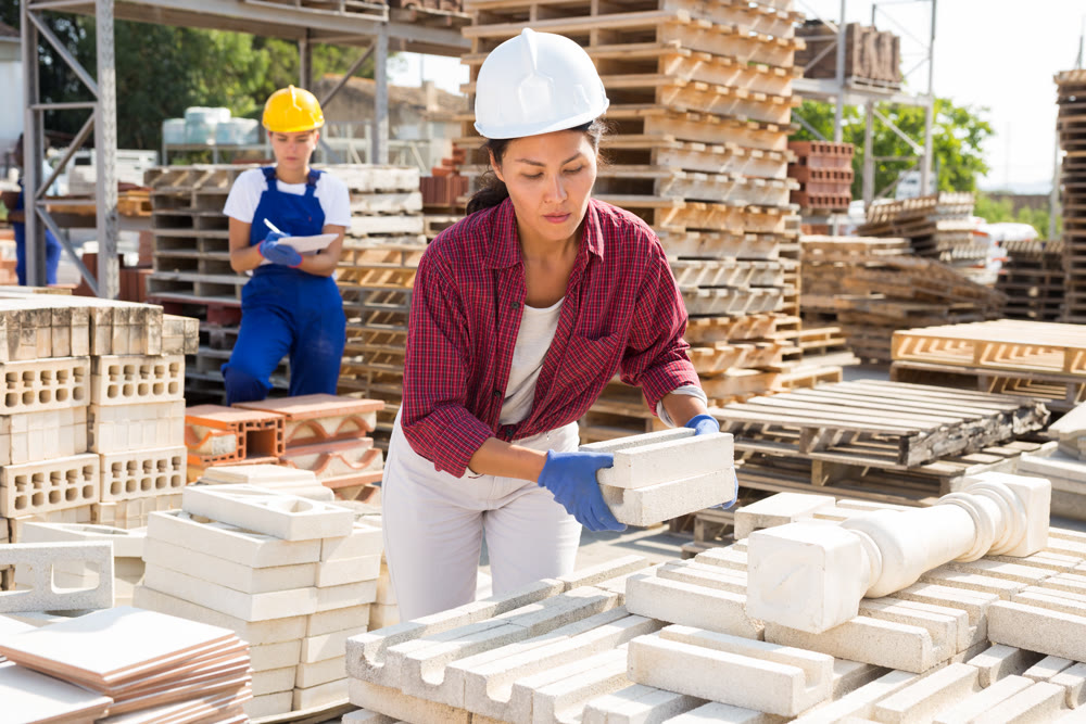 Attentive asian woman is laying bricks