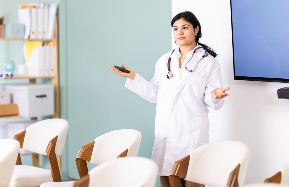 Woman doctor with remote control in lecture hall