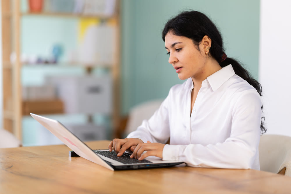 Female works on laptop in room