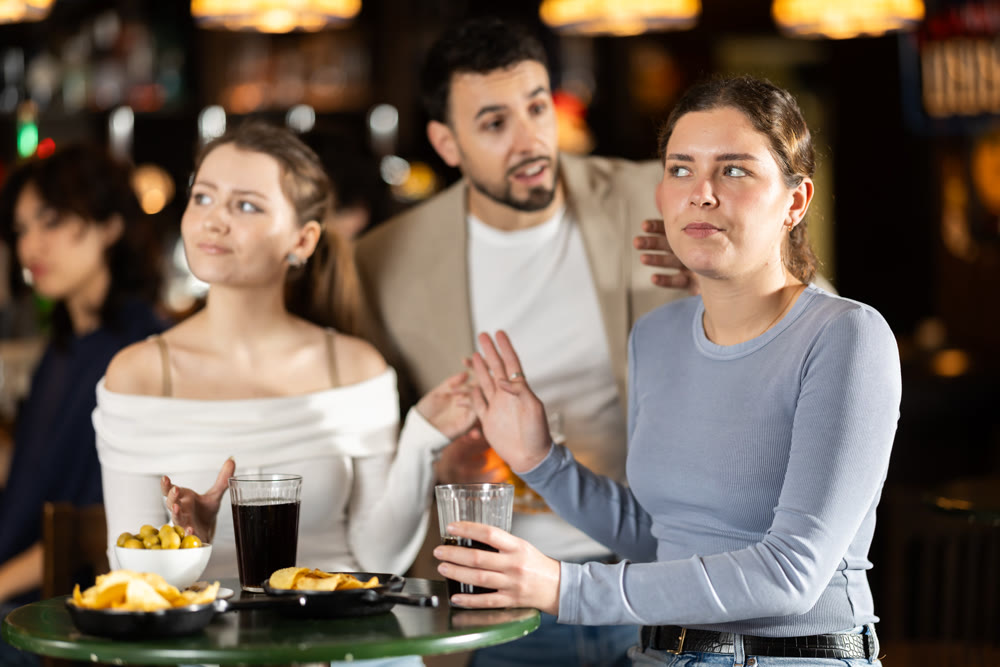 Young man flirting with two women getting rejected