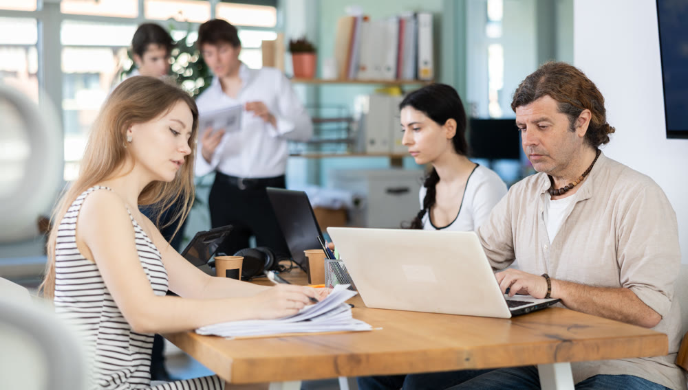Several managers work together in a modern office. Well-coordinated management team