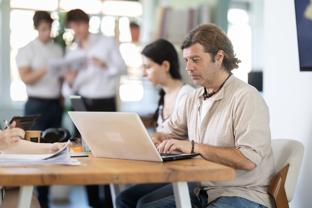 Adult businessman working on laptop in modern office