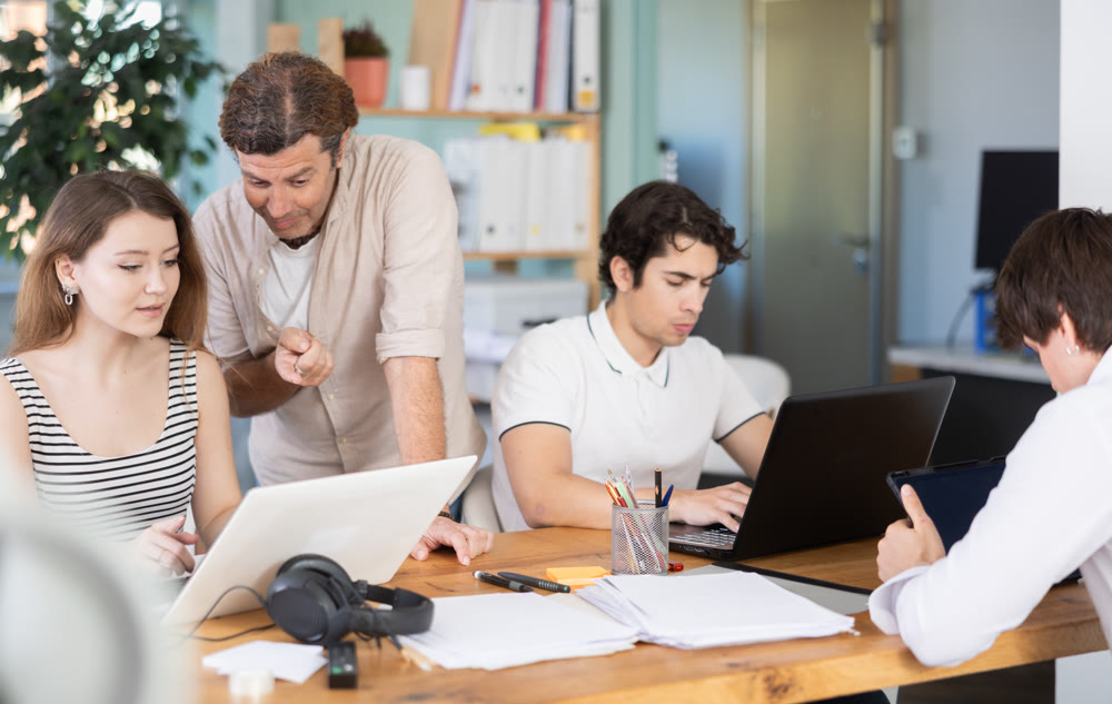Team of managers work together in a modern office with documents and on Internet