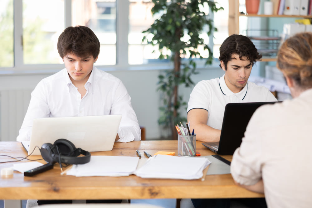 Men working on laptops in office
