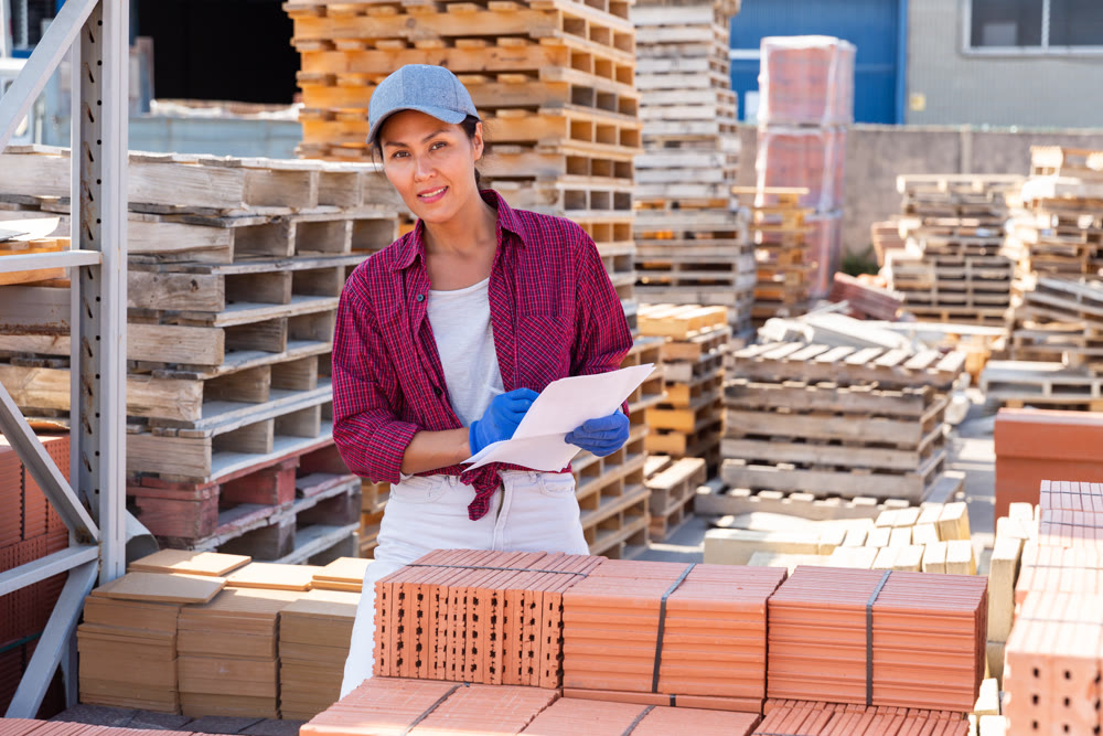 Woman manager leads the accounting of brick at construction site