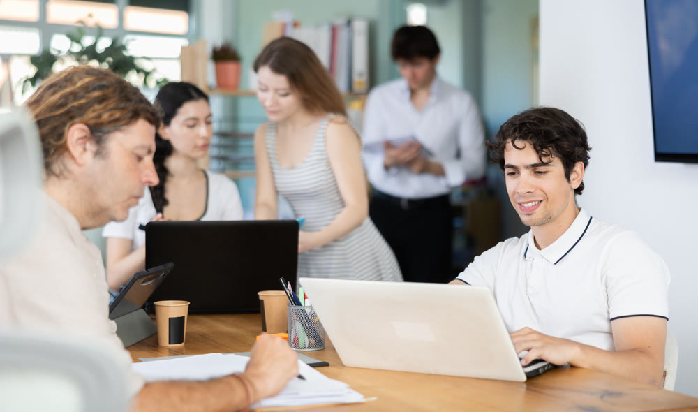 Several managers work together in a modern office. Well-coordinated management team