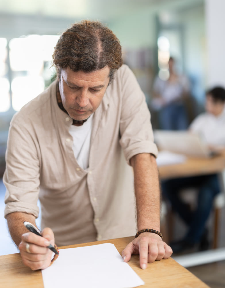 Portrait of manager reading and signing documents in modern office