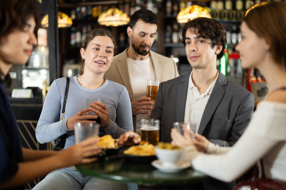 Group of friends happily having time at bar