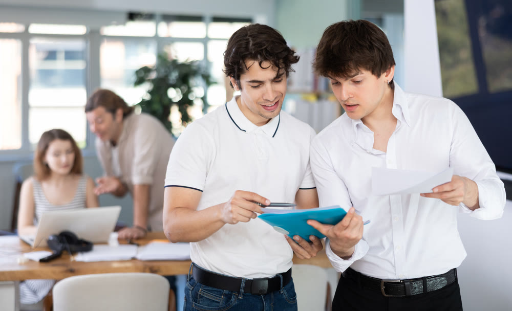 Two men colleagues discussing document