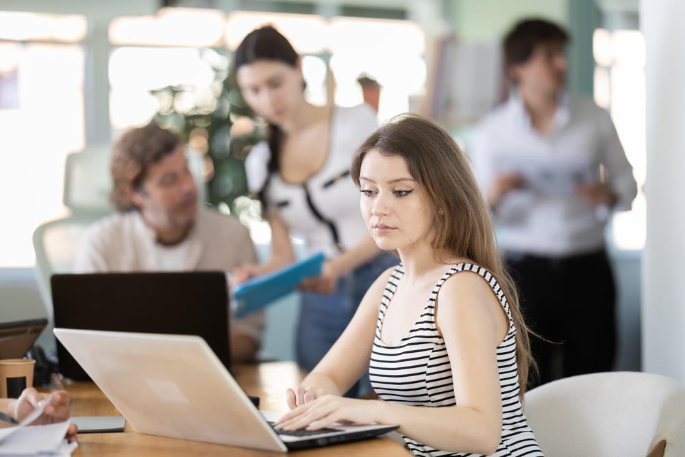 Young woman working on laptop in modern office