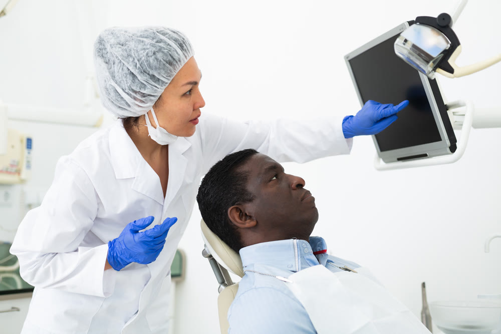 Doctor dentist shows the patient the result of dental x-ray