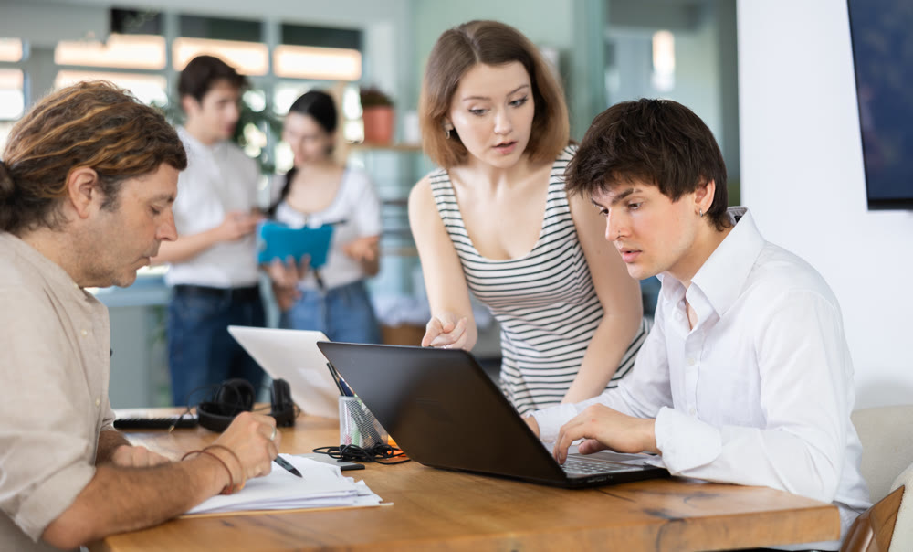 Several managers work together in a modern office. Well-coordinated management team