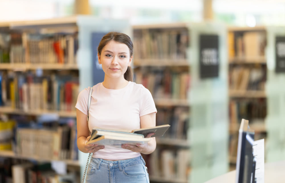 Student with books standing in the library