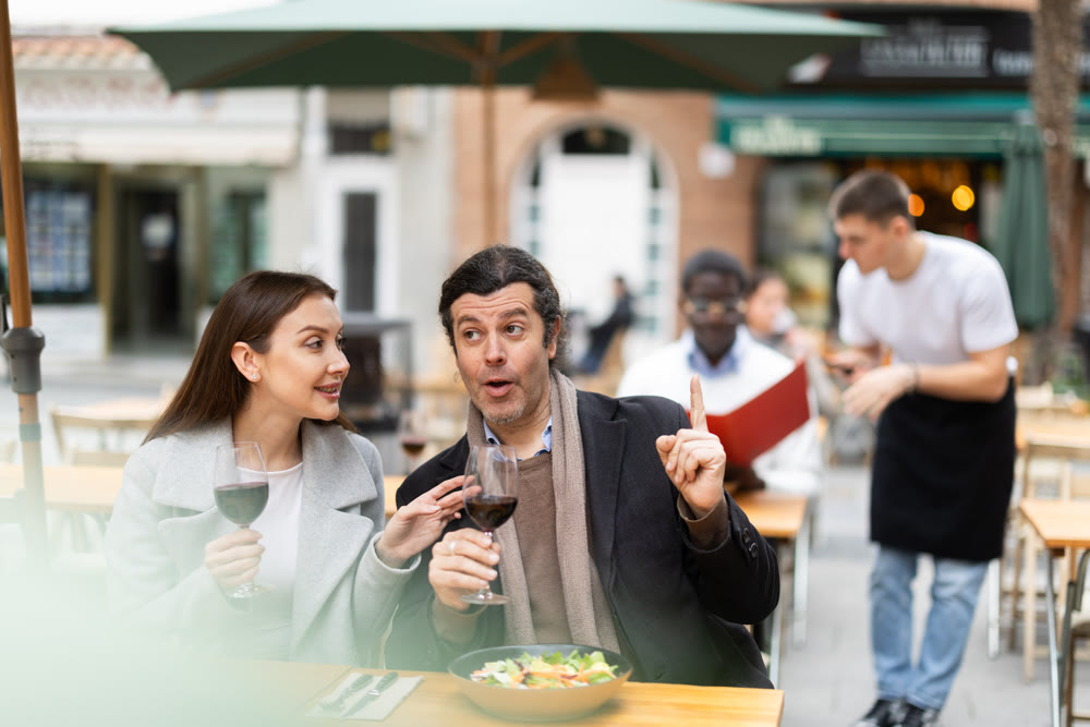 Girl in cafe sits near male companion, has nice conversation and discusses news of day