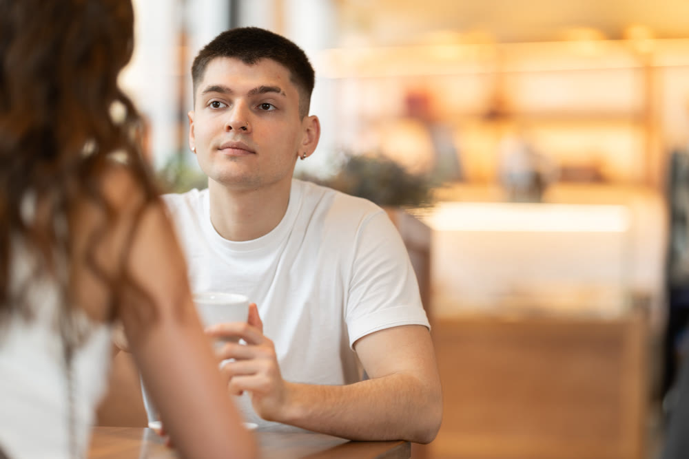 Guy chats with a woman in a coffee shop