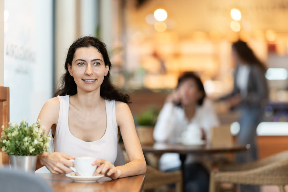 Girl whiles away time and waits for meeting in chain cafe