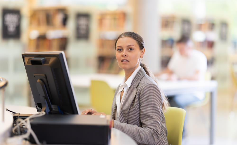 Female student works at computer in library