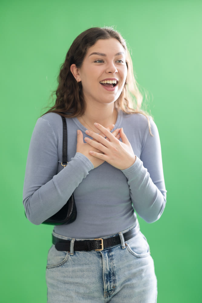 Young woman happy and smiling in front of green screen